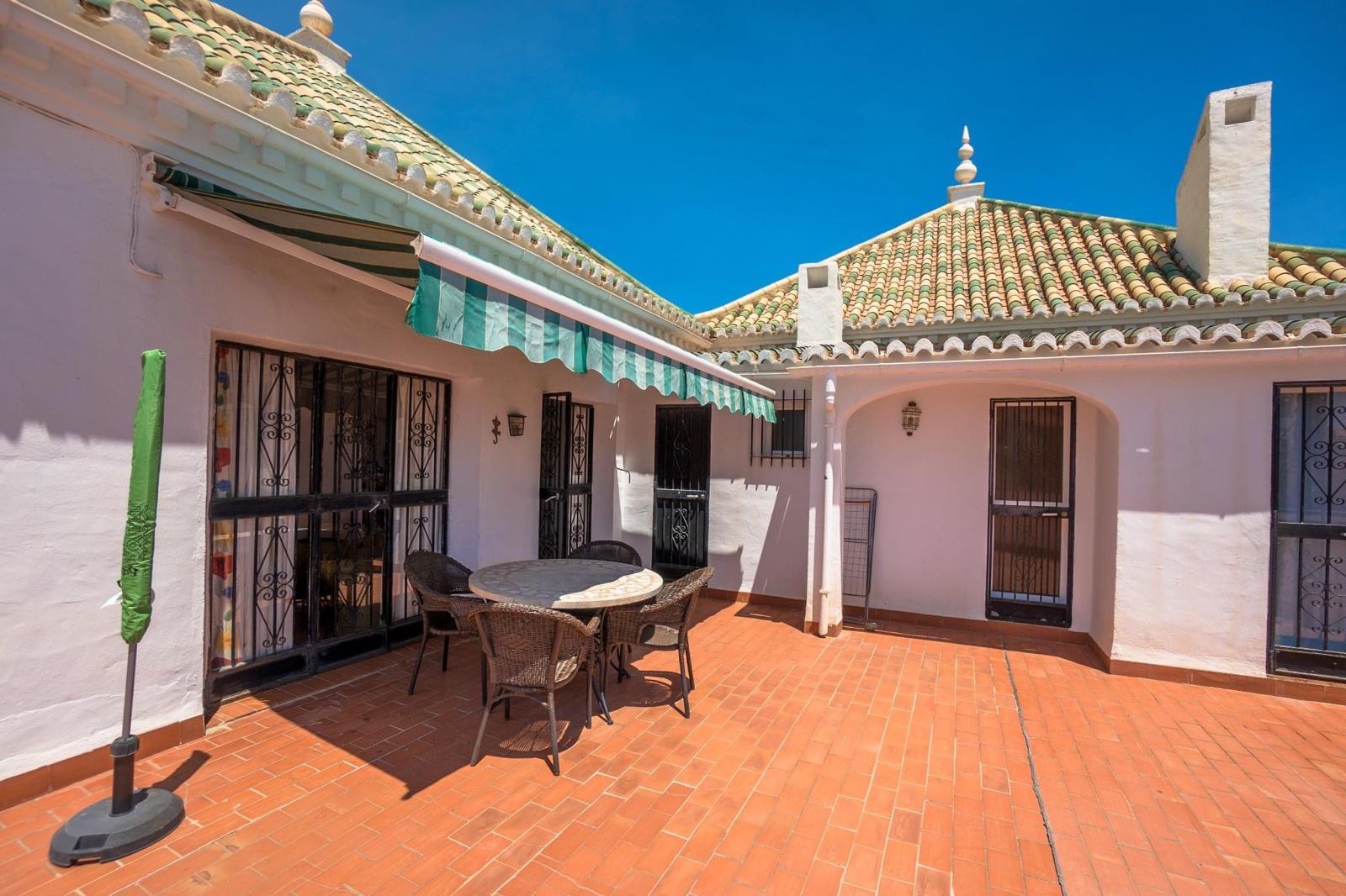Private terrace courtyard with dining table and awnings