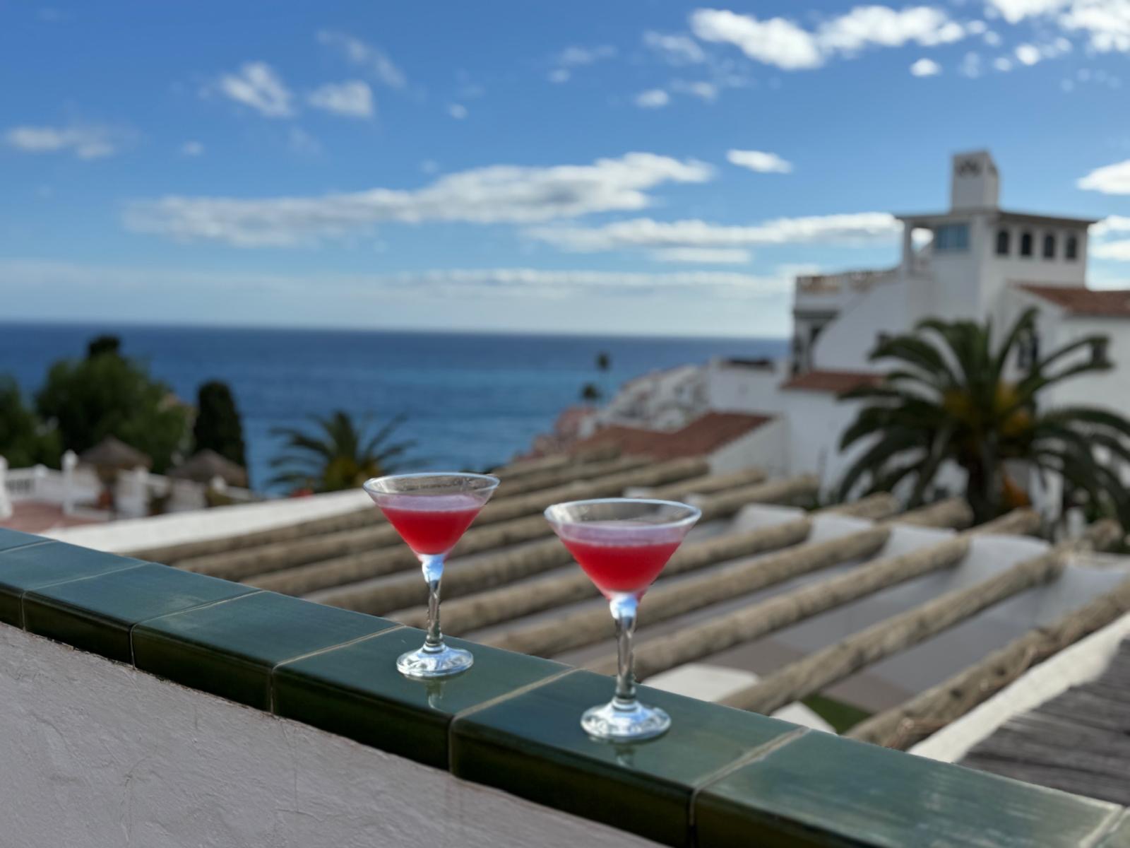 Two cocktails on the tiled terrace wall with sea views