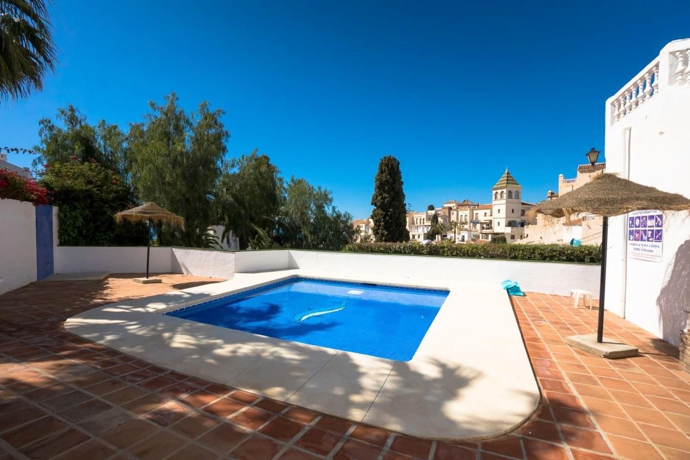 Communal pool with thatched parasols and views to Capistrano Playa