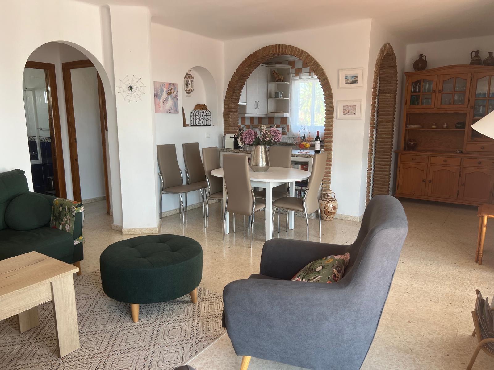 Open-plan living and dining area with arched brick doorway