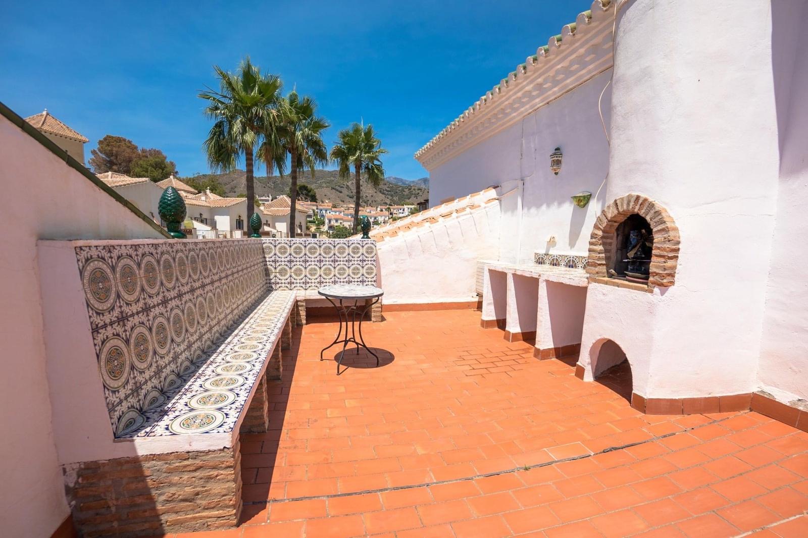 Tiled terrace bench seating and barbecue with mountain views