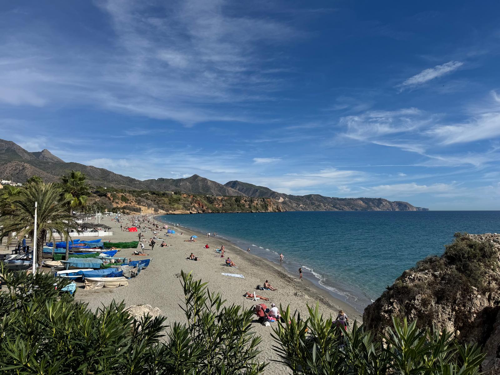 Wide view of Burriana Beach with fishing boats and mountains